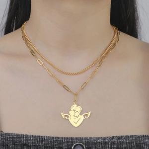 Detail of double-layer gold necklace with angel and baby pendant on paperclip chain