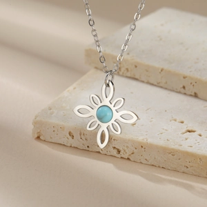 Detail of silver stainless steel Celtic knot pendant with blue turquoise stone inlay