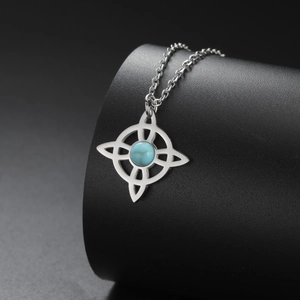 Detailed close-up of a Celtic knot stainless steel necklace with a turquoise stone inlay