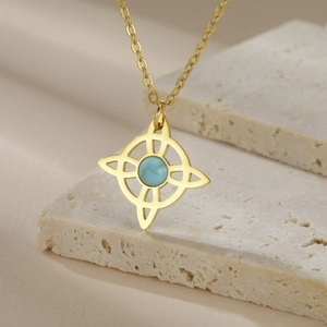 Macro detail of gold Celtic knot pendant with blue turquoise stone and steel chain