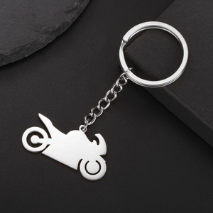 Minimalist stainless steel motorcycle keychain with polished silver finish on black rock