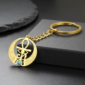Dettaglio dell'Occhio di Horus e Ankh su un ciondolo portachiavi in acciaio dorato