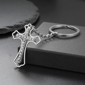 Macro detail of silver stainless steel cross keychain with sparkling crystal inlay