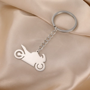 Polished stainless steel motorcycle keychain on silk background with fine metal details