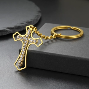 Detailed view of a gold-plated stainless steel cross keychain with sparkling crystals