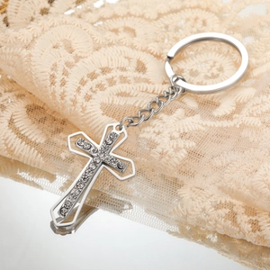 Detailed macro view of silver titanium steel cross keychain with sparkling crystals