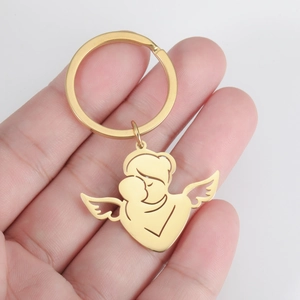Detailansicht eines goldenen Edelstahl-Schlüsselanhängers mit Engel-Mutter-Kind-Anhänger