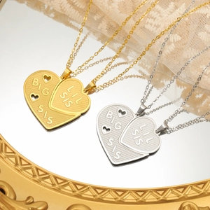 Detailed view of silver and gold heart necklaces engraved with Big Sis and Lil Sis text