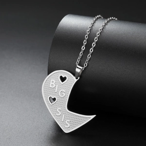 Detailed close-up of BIG SIS engraved stainless steel pendant with heart cut-outs