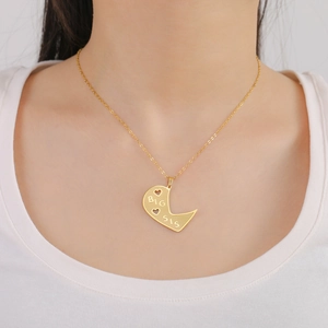 Detail of golden stainless steel necklace with engraved BIG SIS heart pendant on model