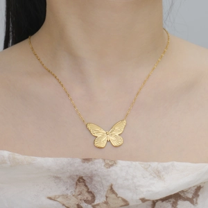 Elegante goldene Schmetterlingshalskette mit Textur am Hals für einen stilvollen Look