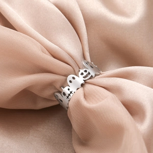 Detail shot of Halloween ring with hollow ghost and skull motifs on pink satin