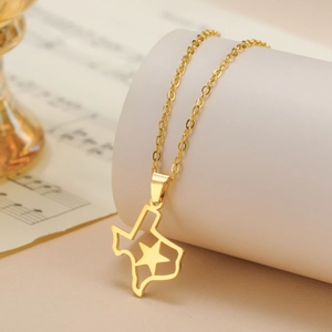 Polished gold Texas map pendant necklace with hollow star on a minimalist display