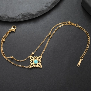 Nahaufnahme der goldenen Hexenknoten-Armbandkette mit himmelblauem Steinbesatz