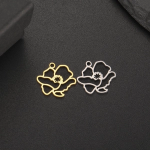 Makroaufnahme goldener und silberner Blumenanhänger für DIY-Schmuck auf schwarzem Hintergrund