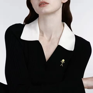 Black knit polo shirt for women featuring a minimalist golden stickman metal brooch