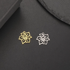 Details von hohlen Blumenanhängern in Gold und Silber auf einem dunklen Hintergrund