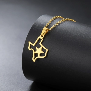 Detail of gold Texas map pendant with cutout star on a black display stand