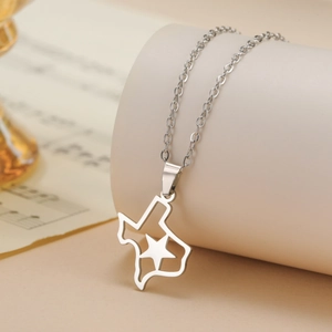 Detail view of Texas map pendant necklace with star cutout on artistic background