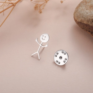 Funny stickman middle finger silver brooch with smiley face on a warm background