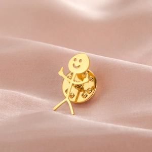 Macro view of gold stickman smiley pin with middle fingers on pink silk fabric