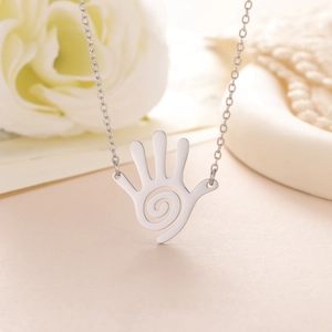 Detailed view of silver hollow spiral palm pendant necklace with fine chain on floral background