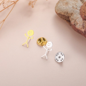 Detailed view of creative gold and silver stickman pins with middle finger gesture