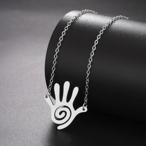 Macro detail of silver stainless steel necklace with hollow spiral palm pendant design