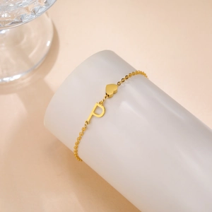 Detail-Makroaufnahme von Goldherz-Anhänger und P-Buchstaben an einem eleganten Armband