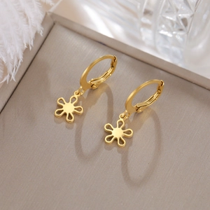 Détail de boucles d'oreilles fleurs dorées avec finition mate et fermoir sécurisé