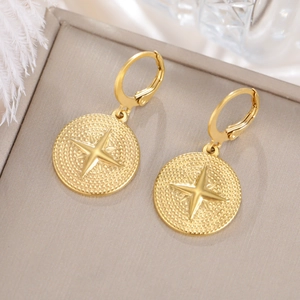 Detalle macro de pendientes bañados en oro 18K con motivo de estrella en soporte
