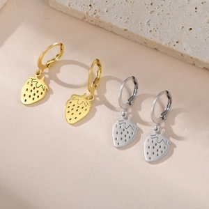 Vue détaillée des boucles d'oreilles créoles avec pendentif fraise en or et argent