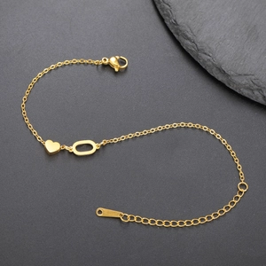 Detailansicht eines goldenen Herzanhänger-Armbands mit Karabinerverschluss auf Stein