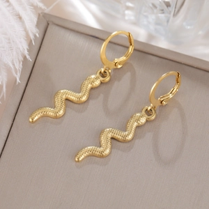 Detalle de pendientes de serpiente bañados en oro de 18K con textura de escamas