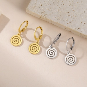 Détail de boucles d'oreilles créoles dorées et argentées avec pendentif spirale