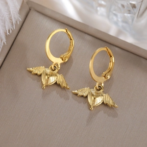 Detalle de pendientes de corazón alado dorado con textura cepillada en expositor