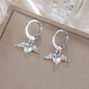 Vista detallada de pendientes de corazón y alas de ángel en caja de joyería fina