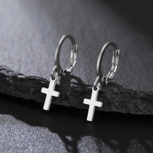 Gros plan de boucles d'oreilles créoles en acier inoxydable argenté avec pendentifs croix