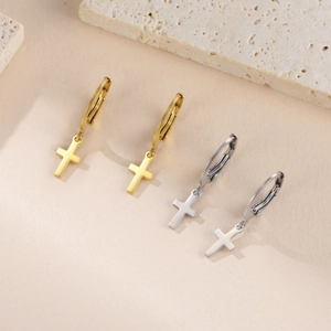 Détail des créoles en acier inoxydable doré et argenté avec pendentifs croix sur pierre