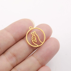 Macro shot of gold hollow heart gesture pendant being held to show small scale