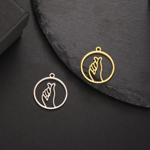 Detailed macro view of gold and silver finger heart pendants for DIY jewelry making