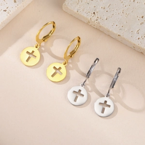 Détail des boucles d'oreilles créoles or et argent avec pendentif circulaire ajouré croix