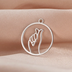Macro detail of a silver finger heart pendant on a soft champagne silk background