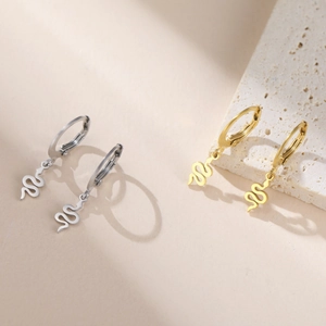 Boucles d'oreilles créoles dorées et argentées avec pendentifs serpent sur une pierre