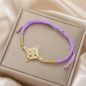 Detailed macro shot of adjustable purple woven bracelet with golden Witch's Knot charm