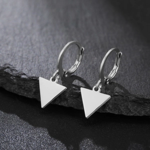 Boucles d'oreilles créoles en acier poli avec breloques triangulaires sur fond en pierre