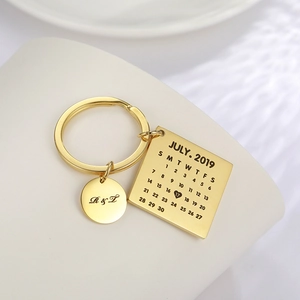 Macro detail of custom gold calendar keychain with engraved date and initials on rings