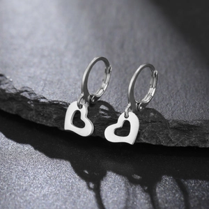 Vue détaillée de boucles d'oreilles créoles avec pendentifs cœur sur pierre