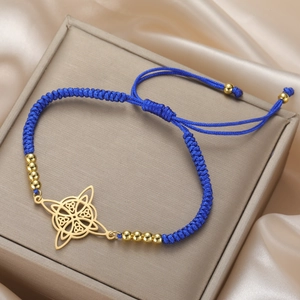 Detail of blue braided bracelet with golden Celtic knot charm on a premium gift box