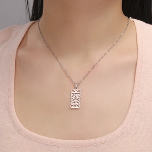 Détail d'un collier avec pendentif masque tribal vintage en argent sur un mannequin